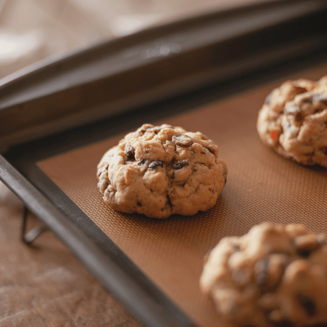 Close-up of freshly baked cookies with chocolate chips on a baking sheet.