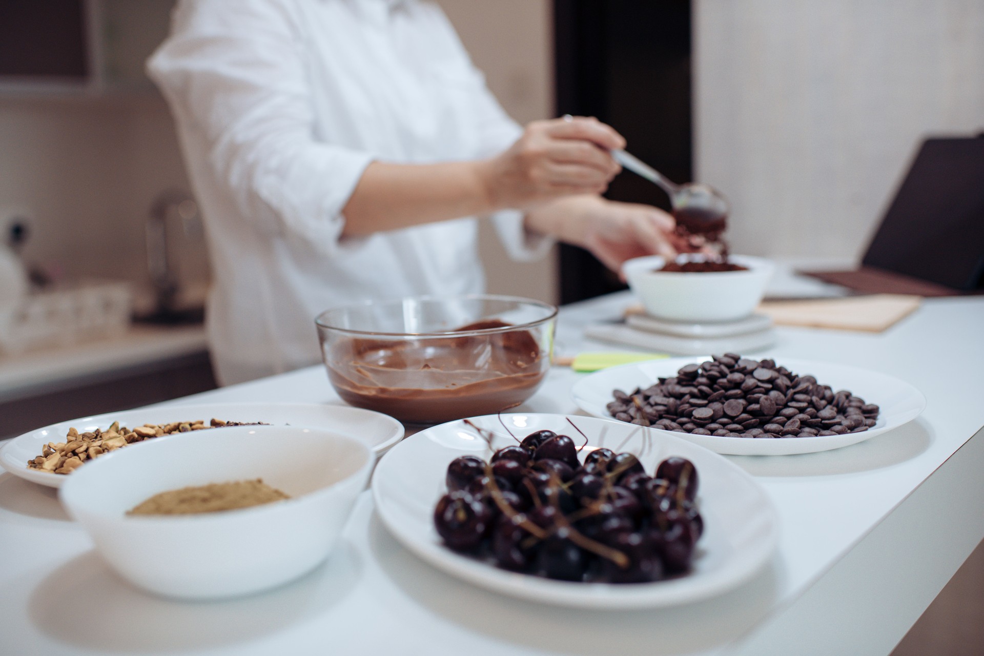 an asian chinese female desert chef preparing chocolate truffles at home with learning from digital tablet e learning recipe weighing ingredient